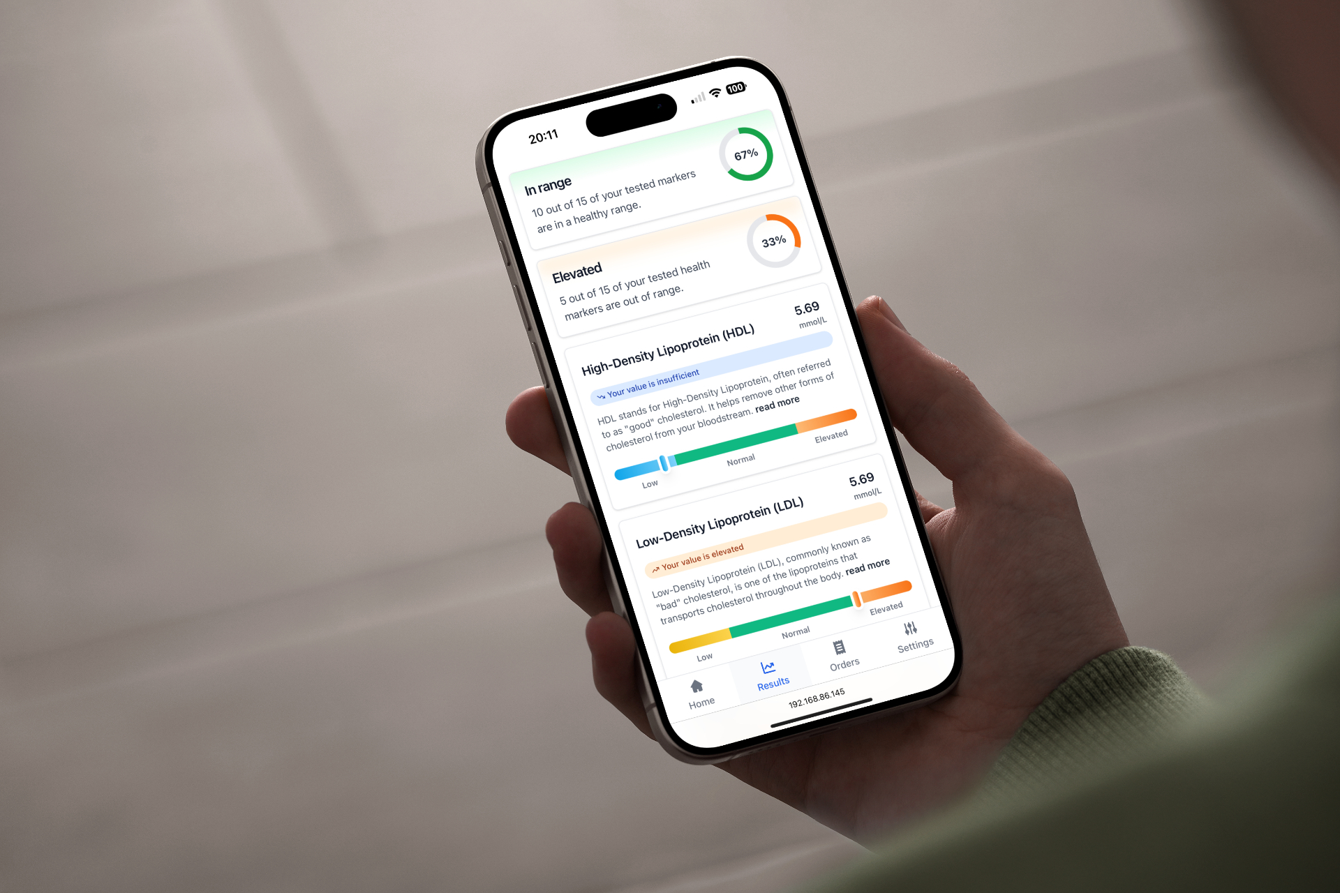Healthtrackr biomarker results app on an iPhone held in hand, showing HDL and LDL ranges