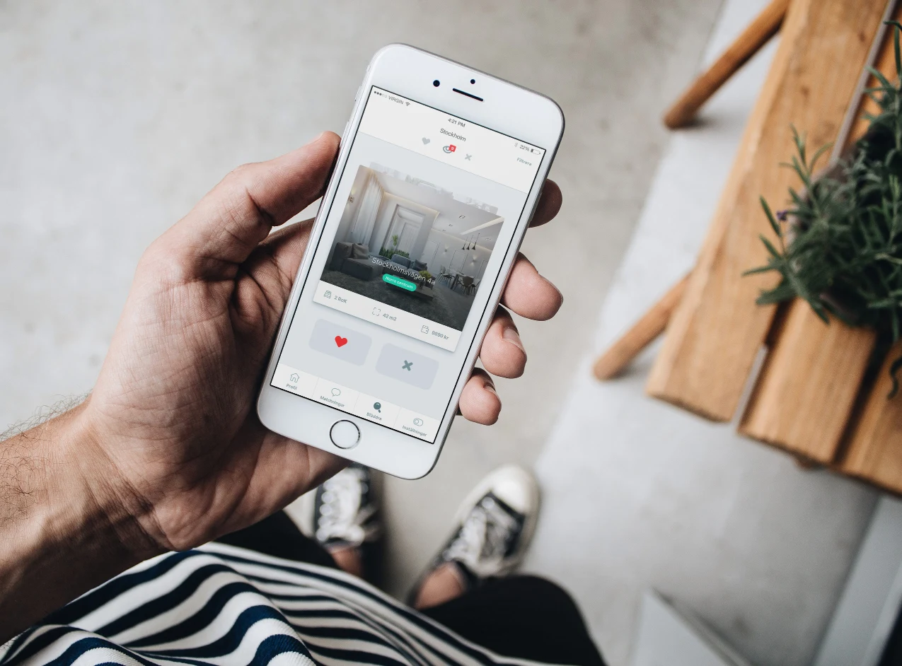 Switchplace swipe-to-match apartment discovery on an iPhone held in hand